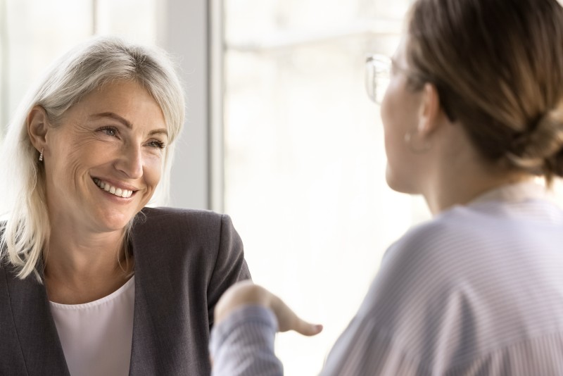middle aged woman discussing her financial goals with her new wealth manager in their office