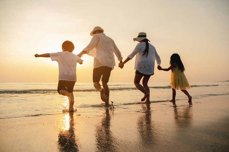 a family having fun on the beach after prioritizing their finances
