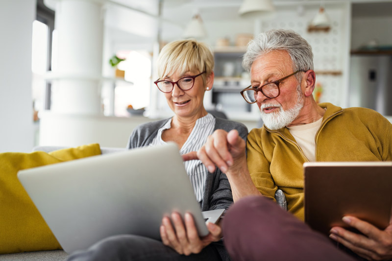 a happy senior couple working with a financial planner on their computer