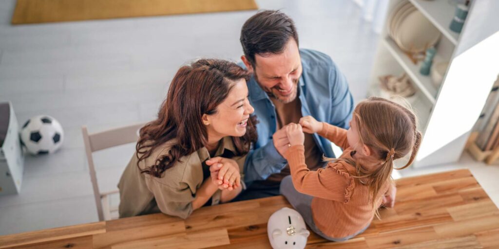 a young family teaching their daughter about finances