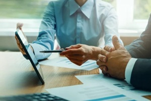 advisor and businessman working with digital tablet at desk in office
