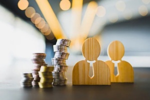 wooden human figures with money coins stack